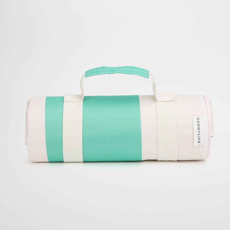 Rolled up green and white picnic blanket with carry handle and Sunnylife label